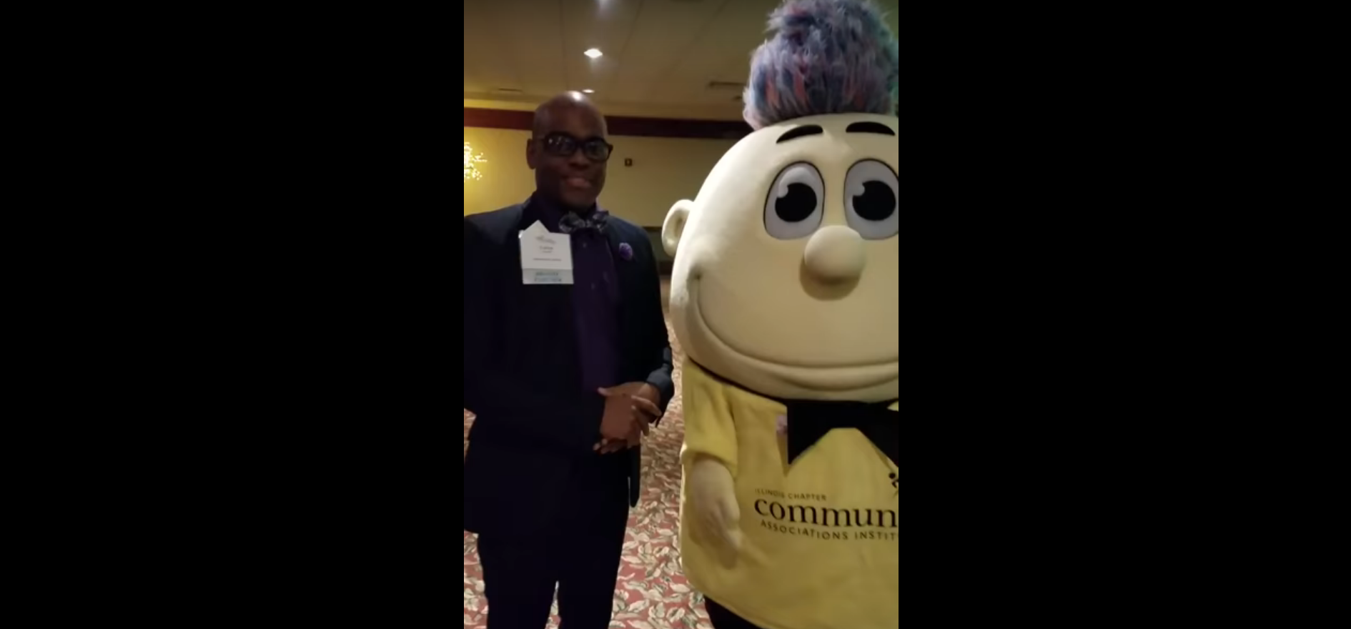 member at CAI conference standing next to a mascot