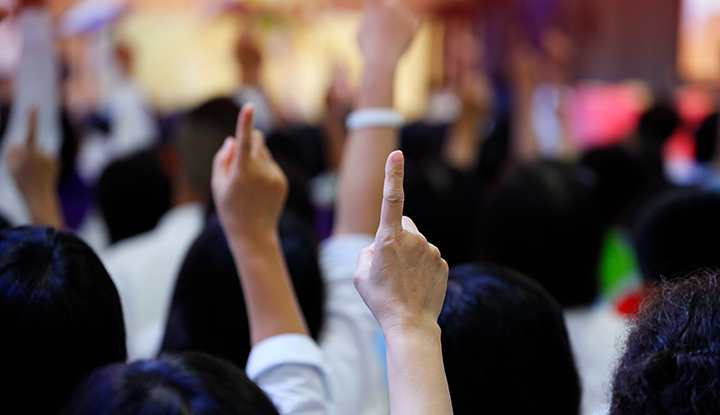 Community members raising their hands