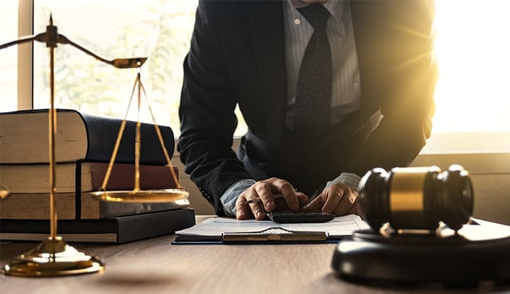 close-up of wooden gavel and lawyer writing