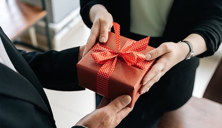 a manager handing a gift to an employee