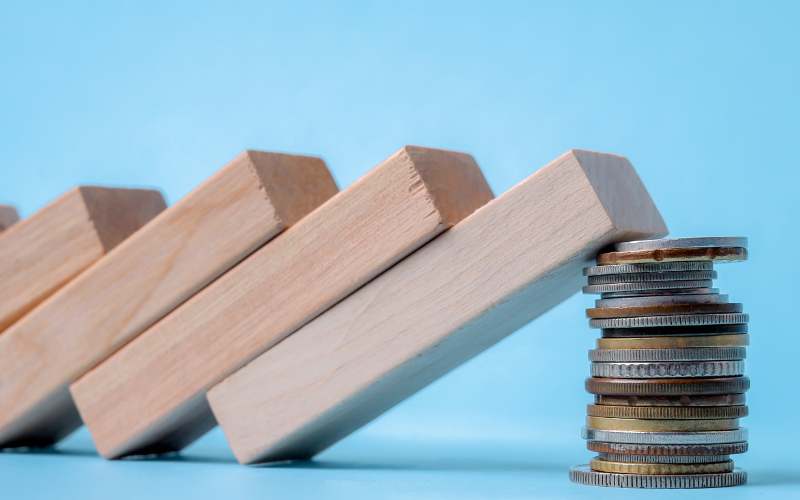 Blocks tumbling onto a stack of coins
