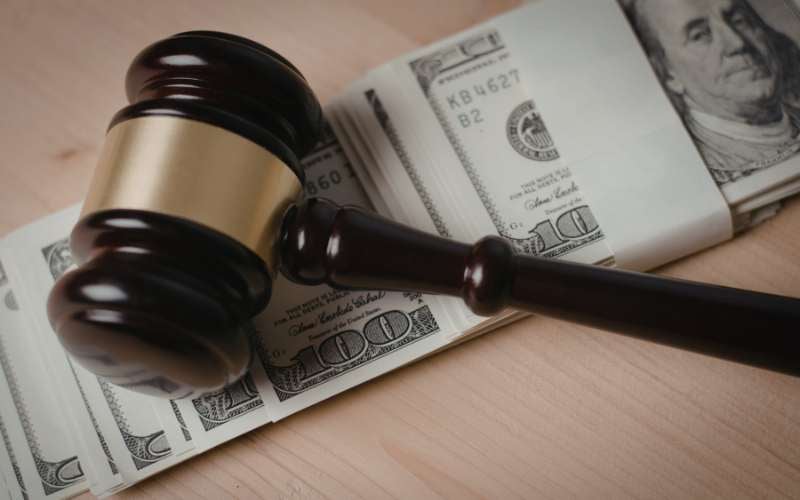 A wooden gavel on US dollar bills