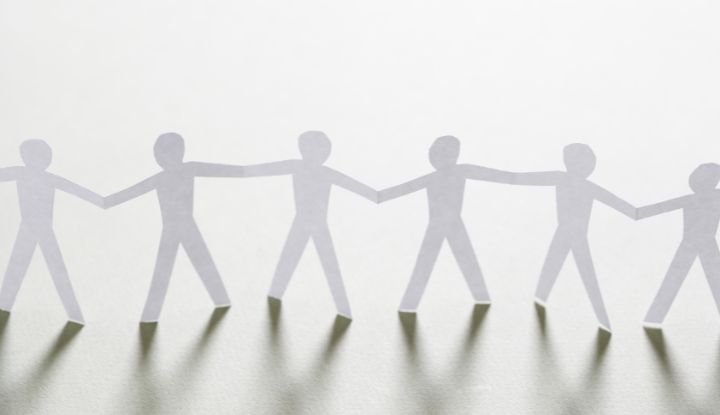 Cutout paper people holding hands