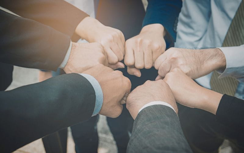 Top view of coworkers fist bumping